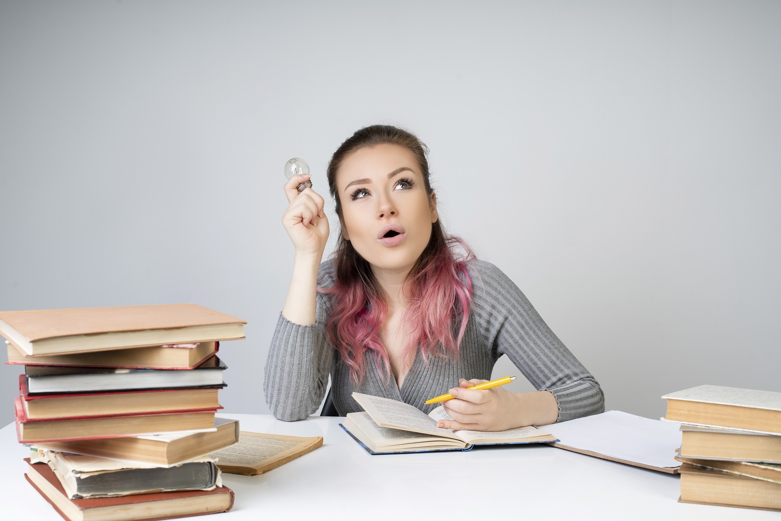 Tips Ampuh Agar Pelajaran Cepat Nempel di Kepala 4 thinking woman holds light bulb writes with yellow pencil