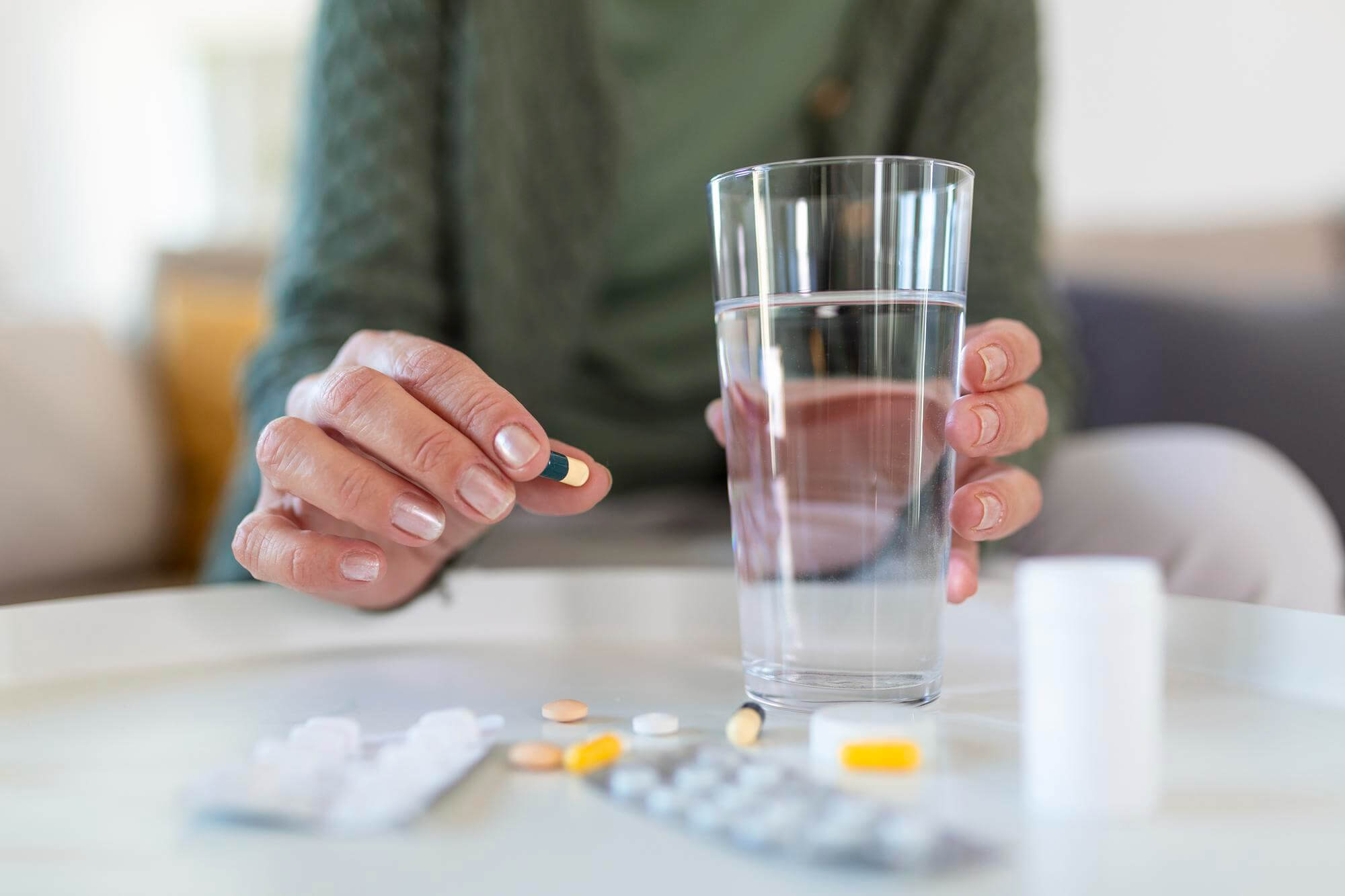 8 Kelompok Orang Dengan Kondisi Tertentu Yang Tidak Boleh Konsumsi Kunyit! 6 senior woman takes pill with glass water hand 1 1