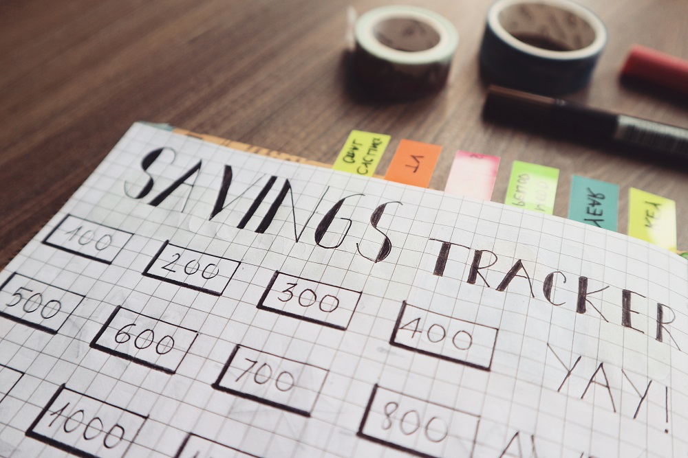 Canva Savings Tracker on Brown Wooden Surface 1