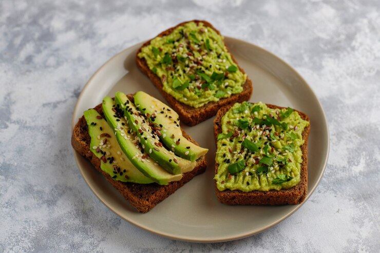 Gampang Dibuat dan Menyehatkan! 5 Camilan yang Bisa Bantu Turunkan Berat Badan! 3 avocado open toast with avocado slices lemon flax seeds sesame seeds black bread slices top view 2831 797