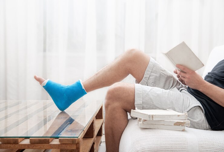 man with broken leg cast reads books against light background interior room 169016 7241
