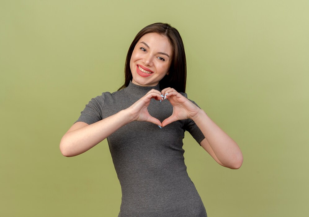 smiling young pretty woman doing heart sign camera isolated olive green background with copy space 141793 31886
