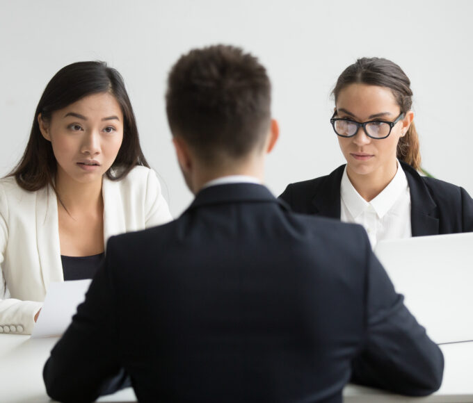 serious unconvinced diverse hr managers interviewing male job applicant