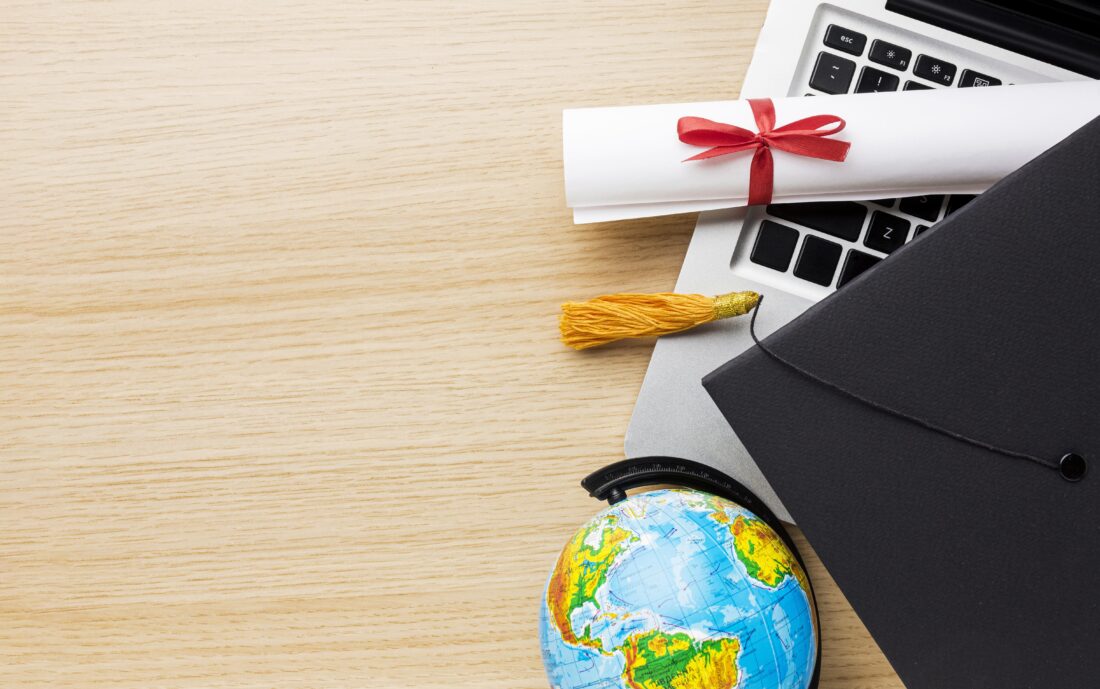 top view globe with academic cap laptop