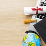 top view globe with academic cap laptop