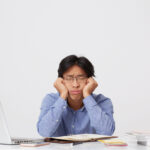 4 Waktu Terbaik Kirim Lamaran Kerja Via Email 5 tired sleepy asian young business man glasses with head hands sitting sleeping workplace table white wall