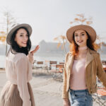 Cara Agar Mempunyai Positive Vibes 8 inspired woman white blouse looking shoulder with smile walking with ginger friend