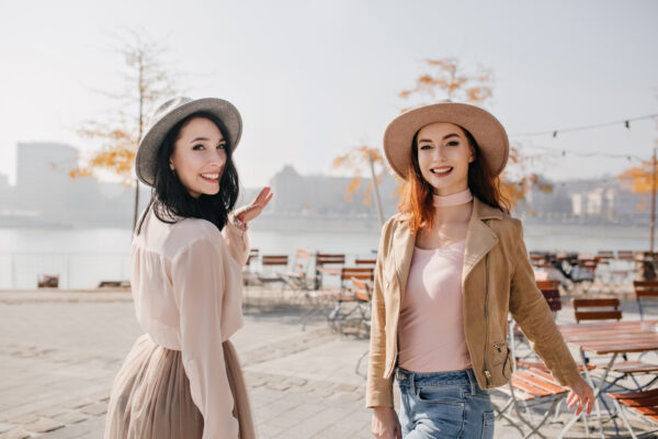 inspired woman white blouse looking shoulder with smile walking with ginger friend