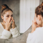 woman home applying cream mask