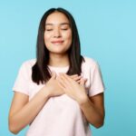 20230831084250 fpdl.in smiling korean woman dreaming holding hands heart close eyes cherish memory her soul stand 1258 83131 large