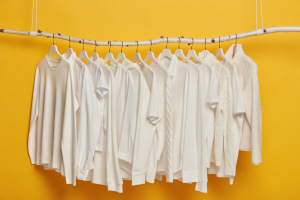 group white plain clothes hanging garment rack rail minimalistic concept apparel women isolated yellow background