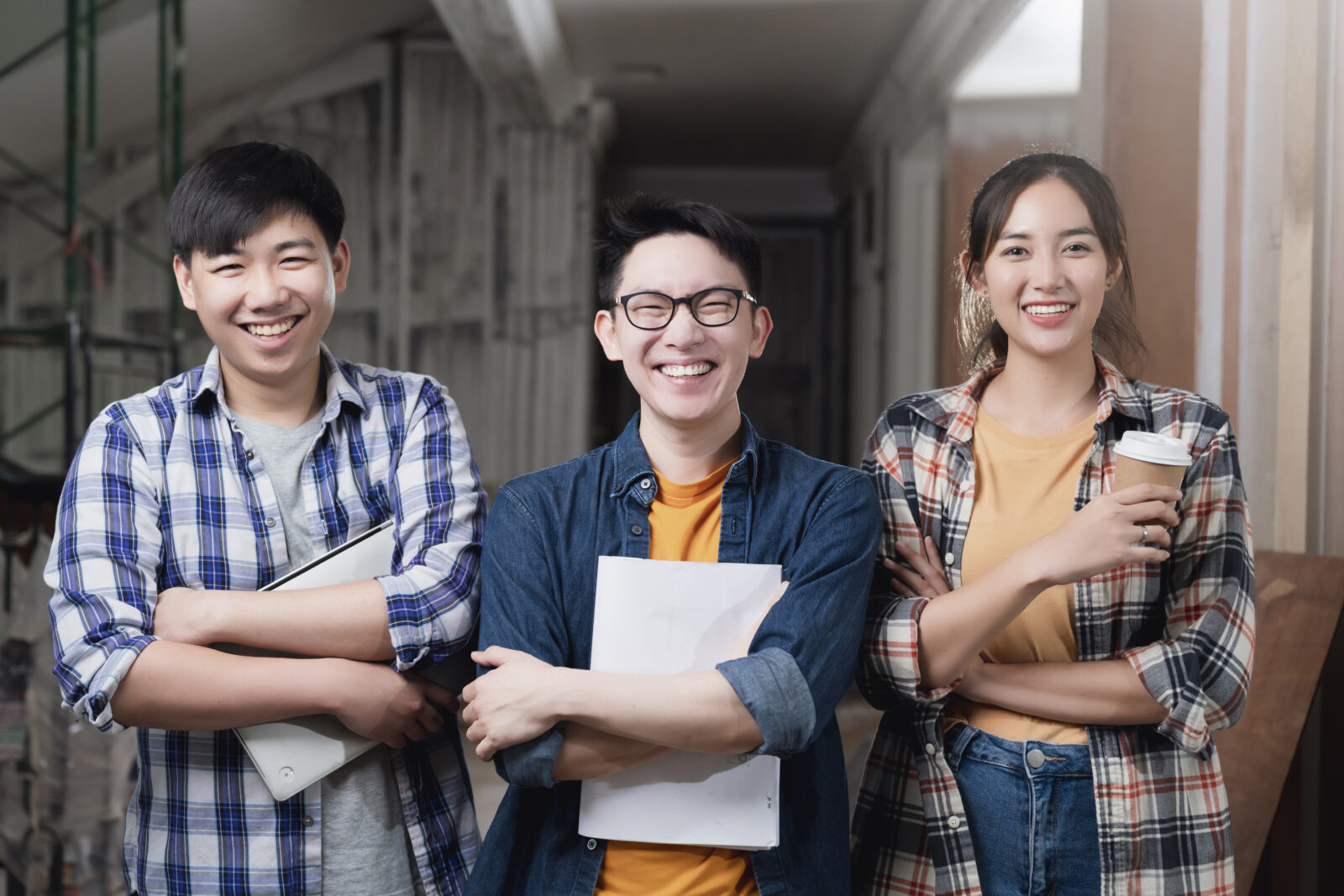smiling asian teamwork yound interior dreative designer portrait stand together hand chest confident smart team with background construction home renovate