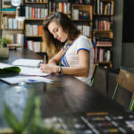 Tips Menulis Karya Tulis Ilmiah Bagi Pemula 5 girl sitting table with notebooks writing