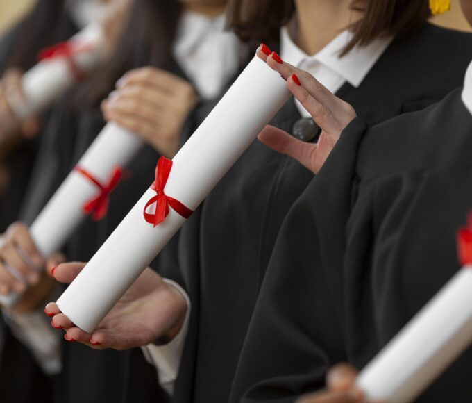 close up people graduating with diplomas