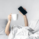 Dilihat dari Kegiatan Sehari-hari yang Tak Bermanfaat, Berikut Adalah Tanda Orang Sulit Sukses 5 woman lies bed with smartphone cup coffee her hands