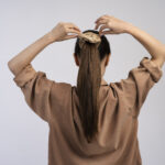 woman tying her hair back view