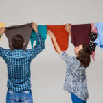 Cara Ampuh Agar Pakaian Cepat Kering di Musim Hujan 5 young beautiful couple hanging wash clothes grey wall