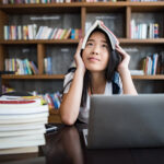 young woman reading book sitting indoor urban cafe