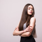 portrait stylish young pretty woman smiling grey t shirt white wall isolated natural look long brown hair crossed arms