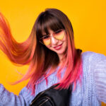 happy woman with unusual pink hairs making selfie yellow wall stylish cozy sweater hearted vintage sunglasses