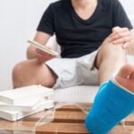 man with broken leg blue splint treatment injuries from ankle sprain reading books home rehabilitation 169016 7240