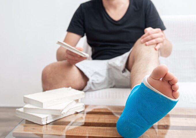 man with broken leg blue splint treatment injuries from ankle sprain reading books home rehabilitation 169016 7240