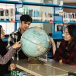 diverse college students looking wolrd globe learning geography together school library 603656 2776