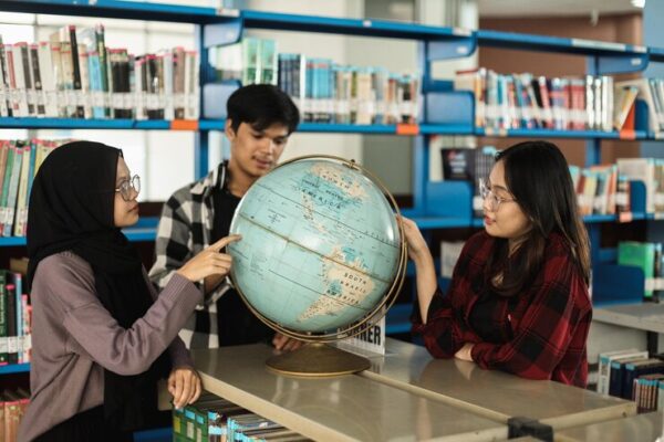 diverse college students looking wolrd globe learning geography together school library 603656 2776