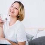 cheerful woman with water reading magazine 23 2147765104