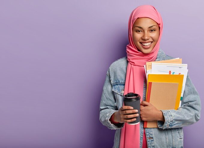 culture religion studying concept glad muslim woman with toothy smile carries notebook with papers takeaway coffee 273609 27053