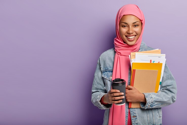 culture religion studying concept glad muslim woman with toothy smile carries notebook with papers takeaway coffee 273609 27053
