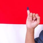 Mengenal Pemilu Dua Putaran: Pengertian, Aturan, dan Syarat yang Perlu Kamu Tahu! 8 man showing finger after voting indonesias presidential election against with indonesia flag 1