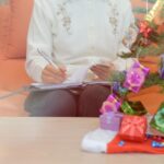 5 Cara Ampuh Atur Keuangan untuk Liburan Natal dan Tahun Baru 5 midsection woman holding paper while sitting table 1048944 27713806
