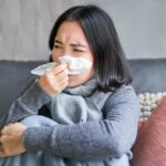 Musim Hujan Tiba! Ini 5 Tips Jitu agar Tidak Gampang Flu 3 close up korean girl sneezing napking sitting home scarf feeling unwell concept winte 1258 131934