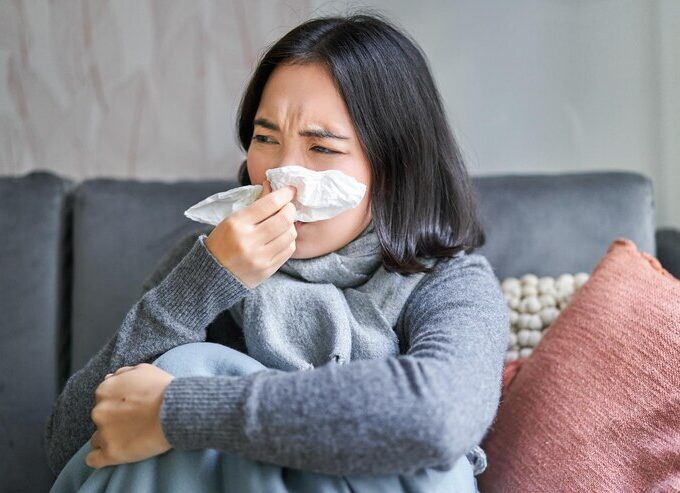 close up korean girl sneezing napking sitting home scarf feeling unwell concept winte 1258 131934