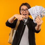 Ini Dia Rata-rata Gaji per Bulan Lulusan SMA-SMK di Indonesia, Yuk Cek! 5 impressed young student girl wearing glasses back bag holding pointing money isolated orange 141793 83841